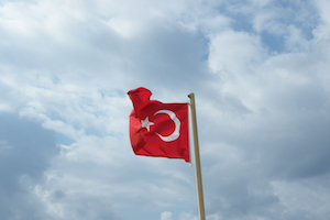 Turkeys flag in front of a cloudy sky